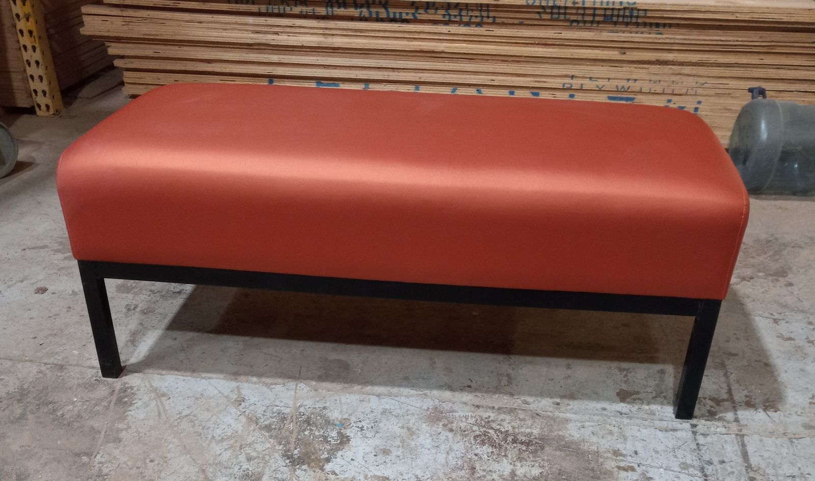 Custom rust-orange upholstered office bench on a black steel frame